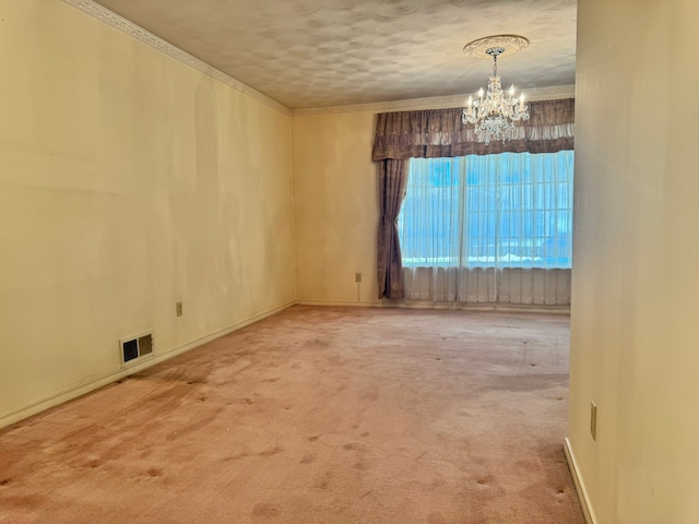 carpeted spare room featuring a notable chandelier, crown molding, and a textured ceiling