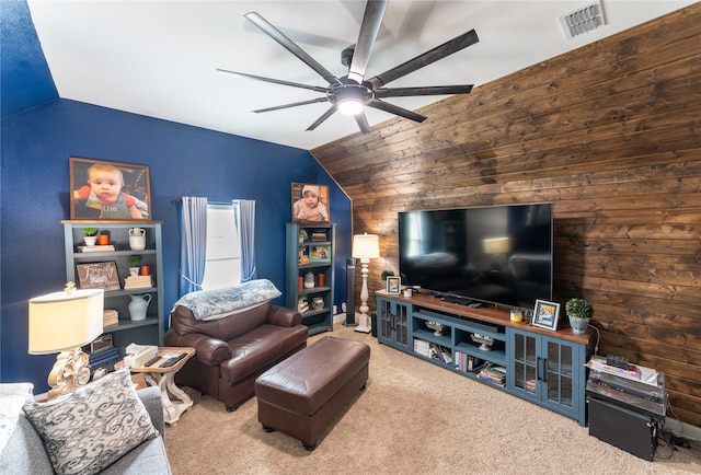 carpeted living room with ceiling fan, wood walls, and vaulted ceiling