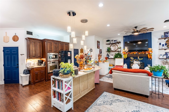 kitchen with stainless steel appliances, ceiling fan, crown molding, dark wood-type flooring, and a kitchen island