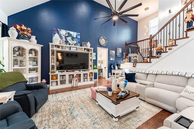 living room featuring a high ceiling, hardwood / wood-style flooring, and ceiling fan