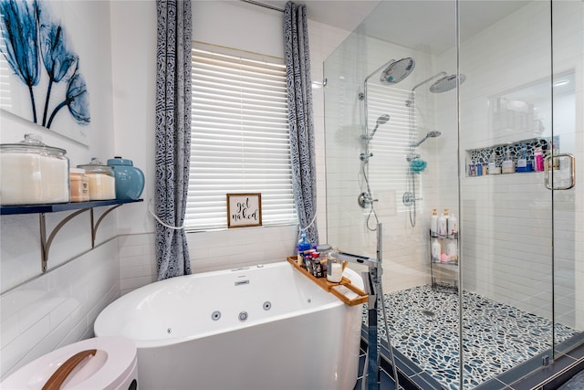 bathroom with toilet, plenty of natural light, independent shower and bath, and tile walls