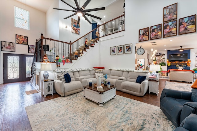 living room with a high ceiling, french doors, ceiling fan, and hardwood / wood-style floors