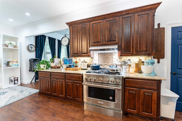 kitchen with light stone countertops, backsplash, ornamental molding, high end stove, and dark hardwood / wood-style floors