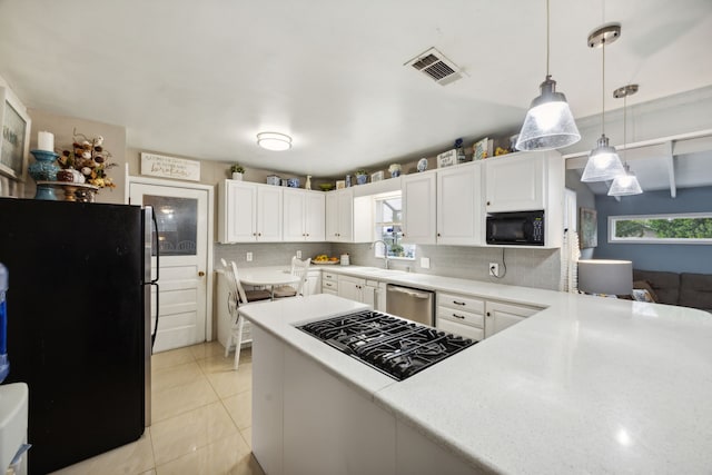 kitchen featuring black appliances, light tile patterned floors, backsplash, white cabinets, and pendant lighting