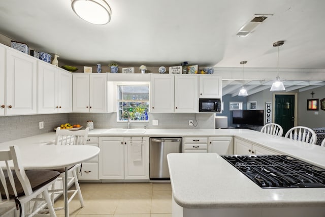 kitchen featuring decorative light fixtures, stainless steel dishwasher, sink, and a breakfast bar