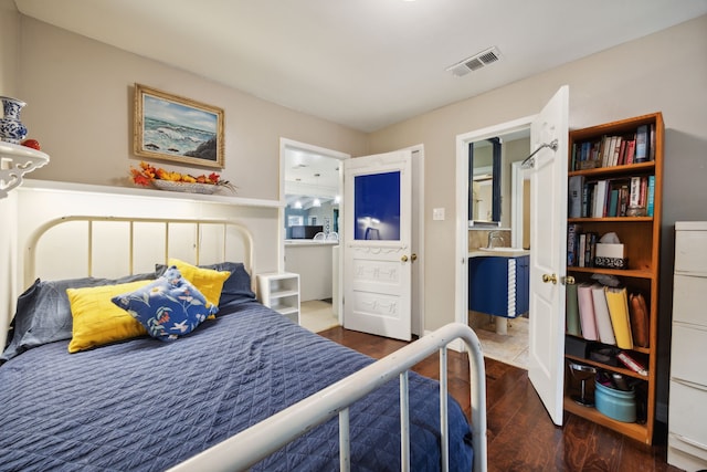 bedroom featuring ensuite bathroom and dark hardwood / wood-style floors