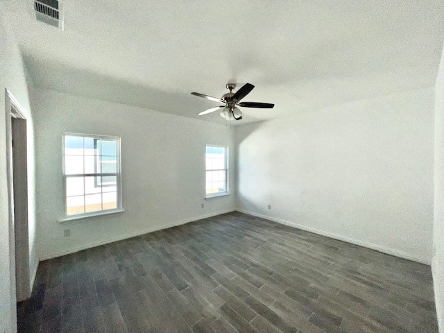 empty room featuring dark wood-type flooring, ceiling fan, a healthy amount of sunlight, and a textured ceiling