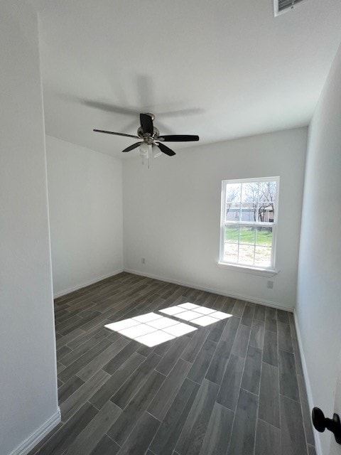 spare room with dark wood-type flooring and ceiling fan