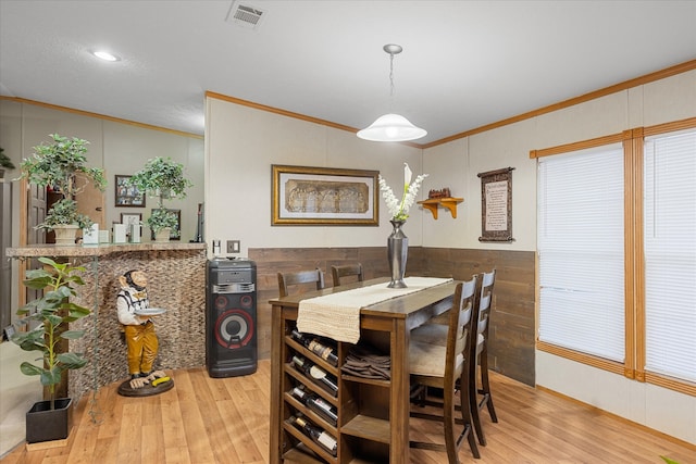 dining room featuring ornamental molding and light hardwood / wood-style floors