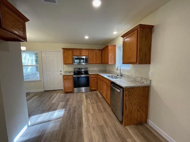 kitchen with sink, light hardwood / wood-style floors, and appliances with stainless steel finishes