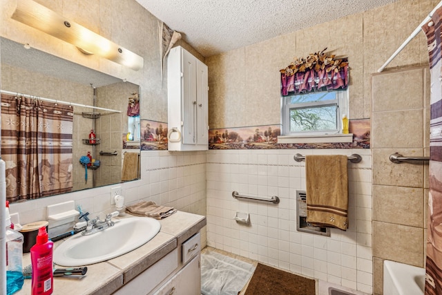 bathroom with shower / bath combination with curtain, vanity, a textured ceiling, and tile walls