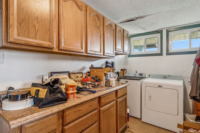 laundry area with washing machine and dryer, a textured ceiling, and light tile patterned floors