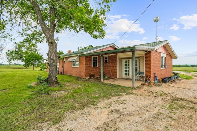 back of property featuring a yard and a patio area