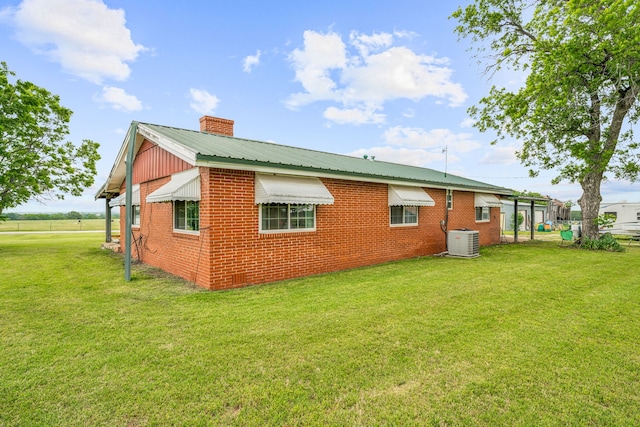 rear view of property featuring central AC and a yard