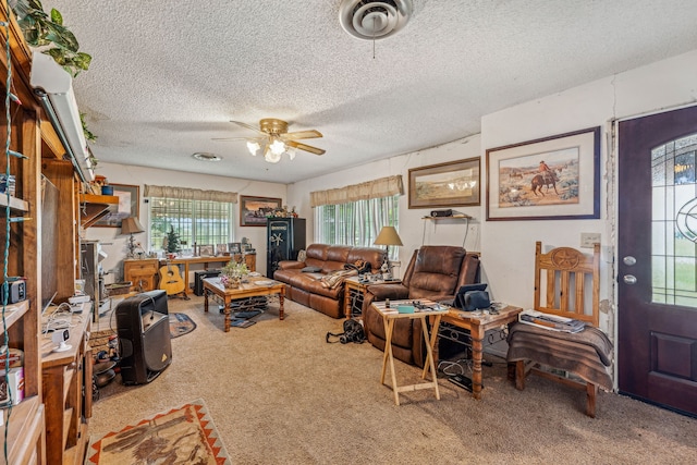 living room featuring ceiling fan, carpet, a textured ceiling, and a healthy amount of sunlight