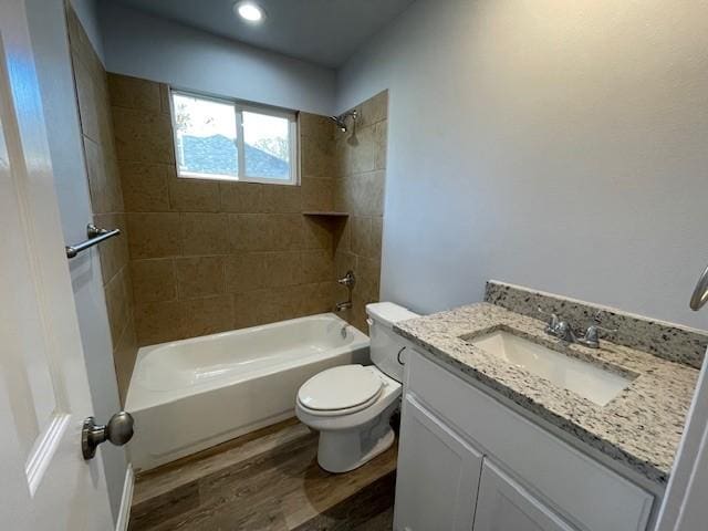 full bathroom featuring tiled shower / bath, toilet, vanity, and hardwood / wood-style flooring