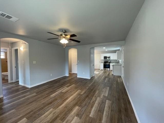 unfurnished living room with ceiling fan, dark hardwood / wood-style flooring, and sink