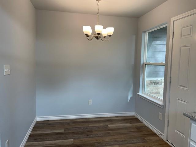 interior space featuring dark wood-type flooring and an inviting chandelier