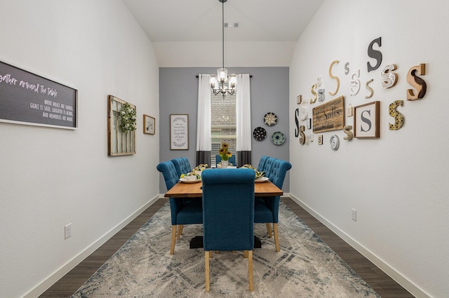 dining room with dark hardwood / wood-style flooring and a notable chandelier