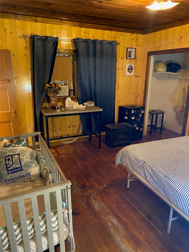 bedroom with dark hardwood / wood-style flooring, wooden walls, and wooden ceiling