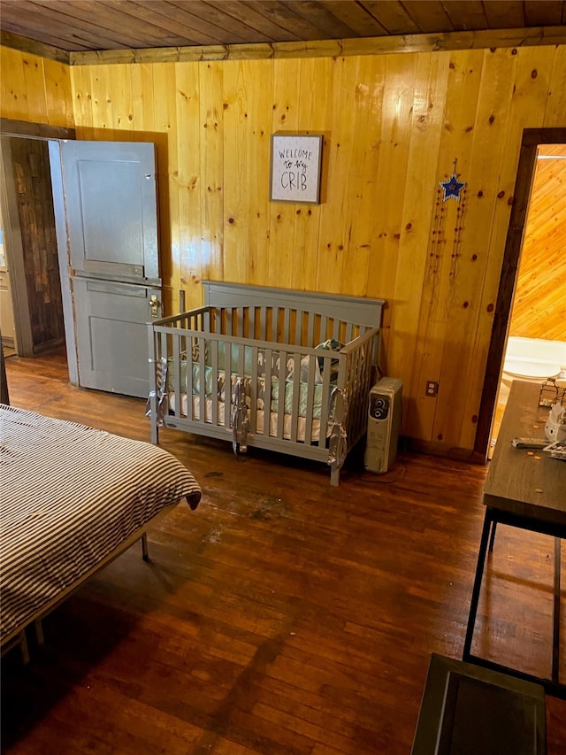 bedroom featuring dark hardwood / wood-style flooring, wood walls, and wood ceiling