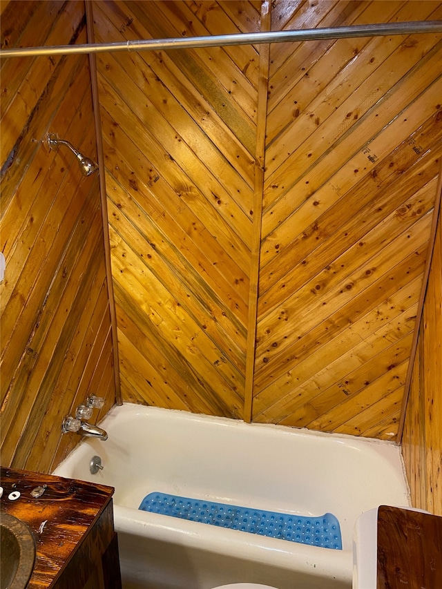 bathroom featuring wooden walls and a tub to relax in