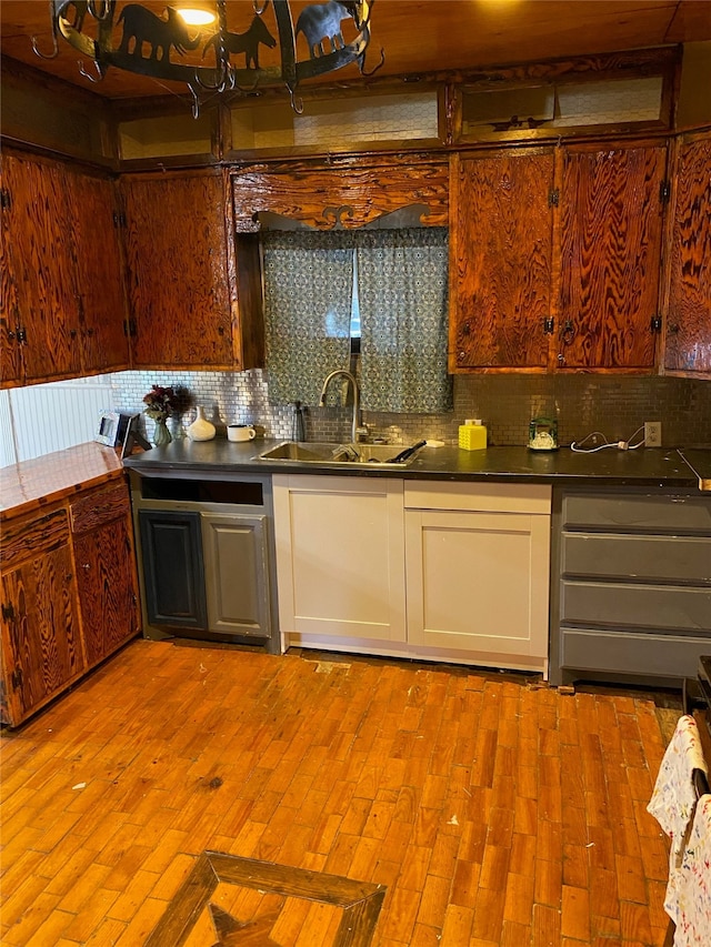 kitchen with backsplash, sink, and light hardwood / wood-style flooring