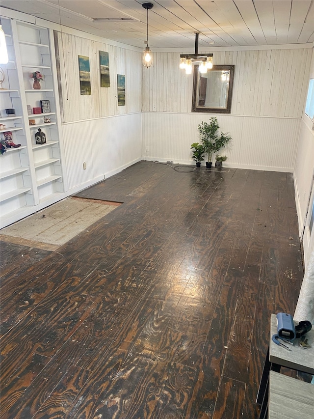 basement with built in features, dark wood-type flooring, wooden walls, and wooden ceiling