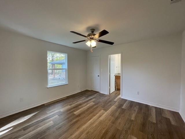 unfurnished bedroom with a closet, dark hardwood / wood-style floors, and ceiling fan