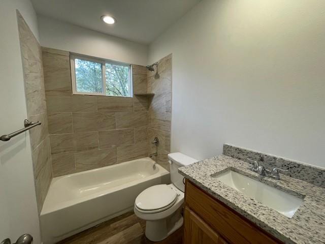 full bathroom with tiled shower / bath combo, toilet, wood-type flooring, and vanity