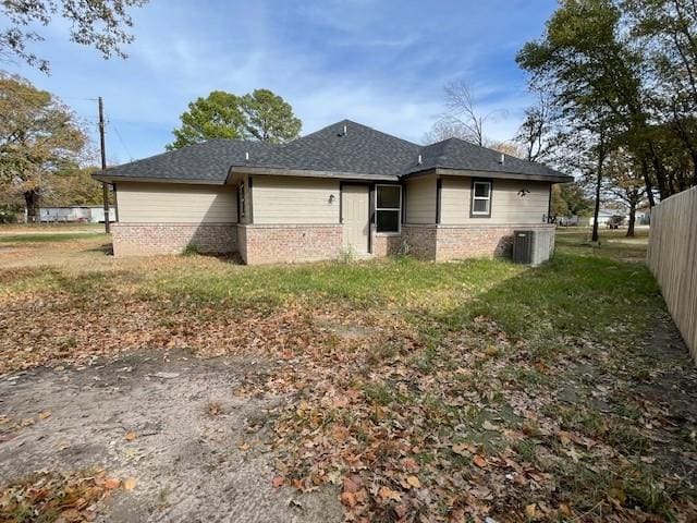 view of side of home with a yard and central AC