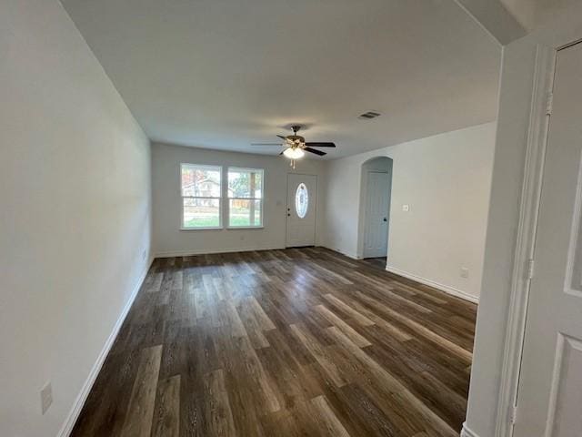 unfurnished living room featuring ceiling fan and dark hardwood / wood-style flooring