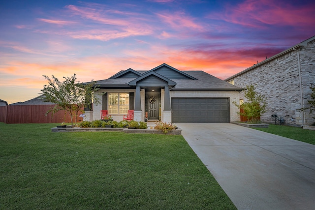 view of front of property with a garage and a yard