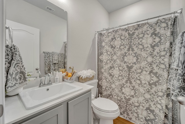 bathroom featuring toilet, vanity, wood-type flooring, and curtained shower