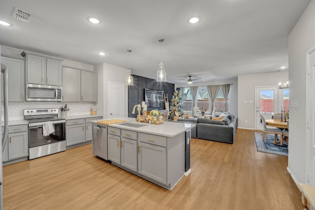 kitchen with gray cabinetry, sink, and stainless steel appliances