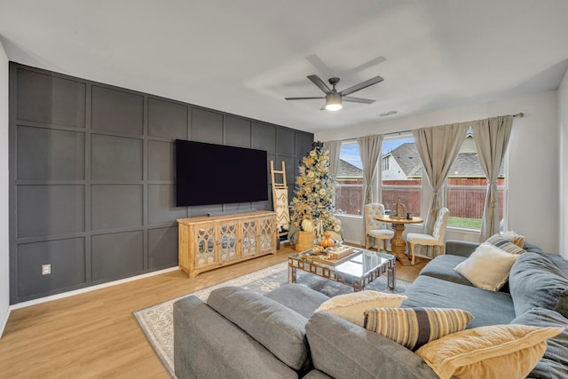 living room featuring ceiling fan and light hardwood / wood-style floors