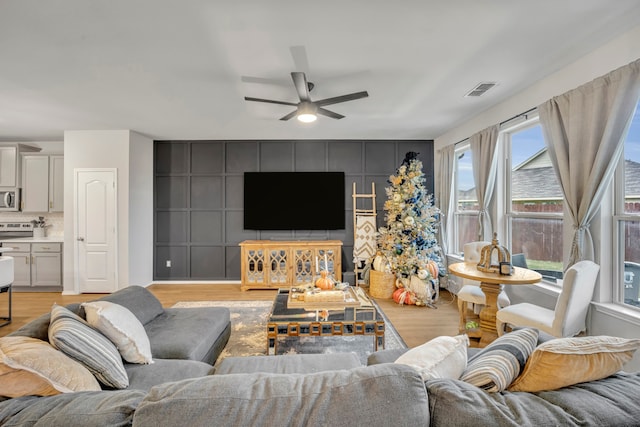 living room featuring ceiling fan and light wood-type flooring