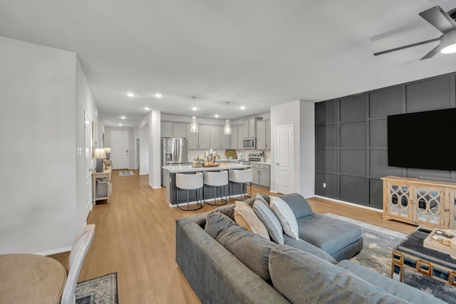 living room featuring light hardwood / wood-style floors and ceiling fan