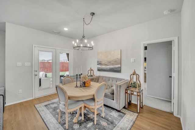 dining space with an inviting chandelier and light hardwood / wood-style floors