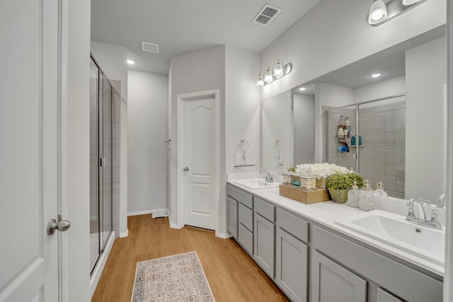 bathroom featuring hardwood / wood-style floors, vanity, and an enclosed shower