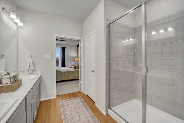 bathroom featuring hardwood / wood-style floors, vanity, ceiling fan, and a shower with shower door