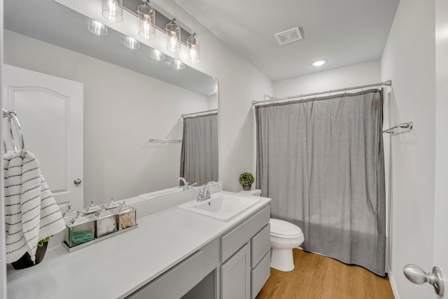 bathroom with toilet, a shower with curtain, vanity, and hardwood / wood-style flooring