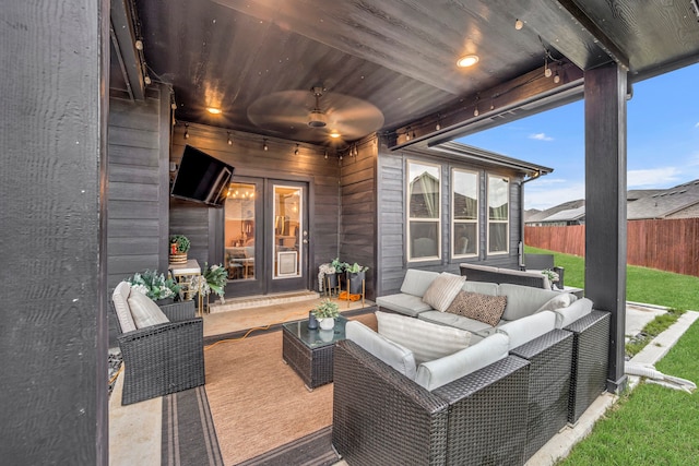 wooden deck featuring ceiling fan, a patio, an outdoor hangout area, a lawn, and french doors