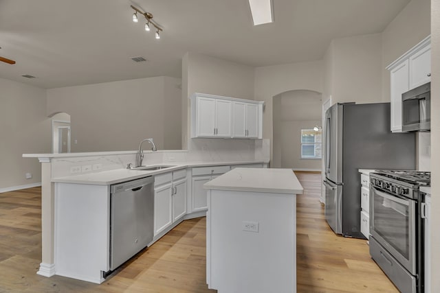 kitchen with stainless steel appliances, white cabinets, and a kitchen island