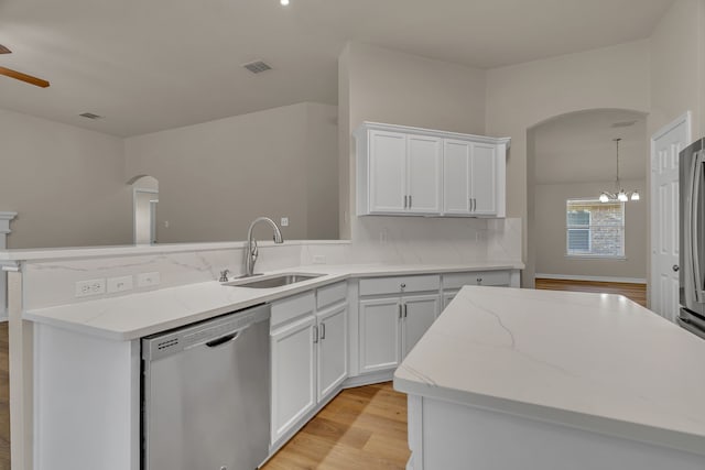 kitchen with a center island, white cabinets, sink, light wood-type flooring, and appliances with stainless steel finishes