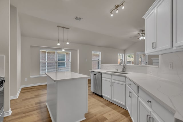 kitchen featuring white cabinets, lofted ceiling, sink, and decorative light fixtures