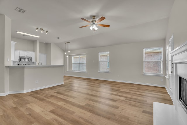 unfurnished living room with ceiling fan, light wood-type flooring, and lofted ceiling