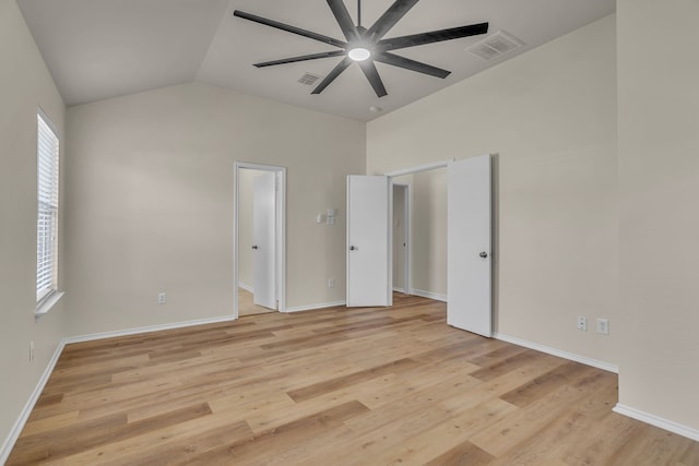 unfurnished bedroom with light hardwood / wood-style floors, multiple windows, and vaulted ceiling