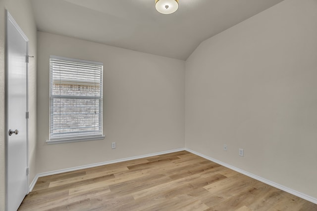 empty room featuring light wood-type flooring and lofted ceiling