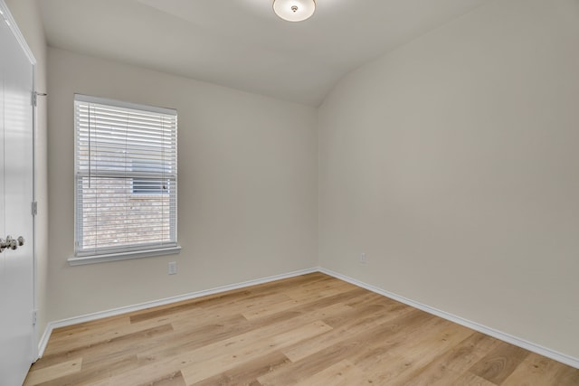 empty room featuring light wood-type flooring and lofted ceiling